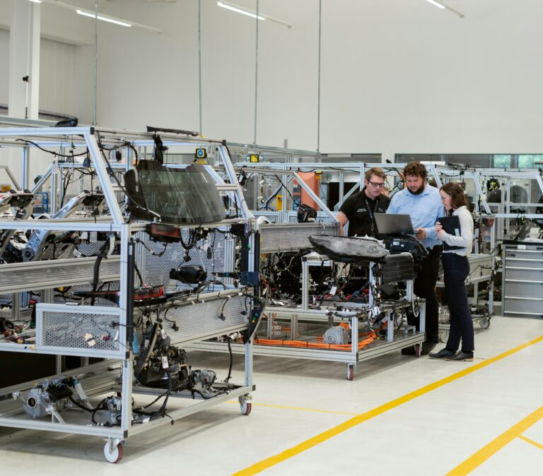 Team of engineers discussing projects in a high-tech factory setting.
