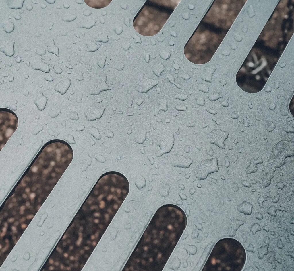 Detailed view of raindrops on a metallic surface showcasing texture and pattern.