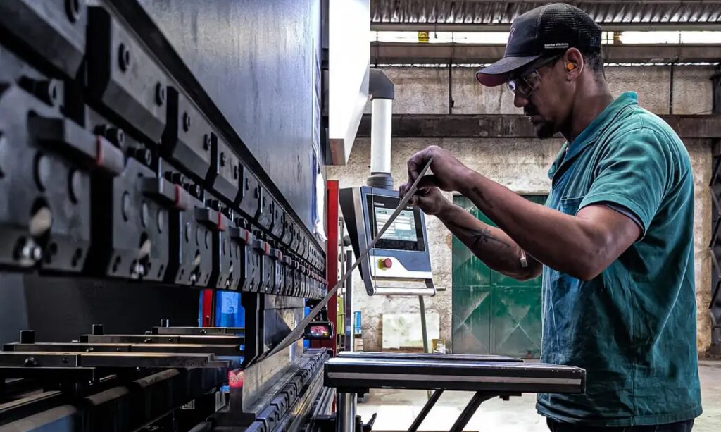 Engineer using machinery in a factory setting, focusing on precision and skill.