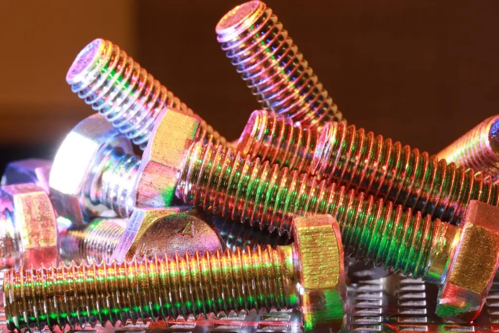 Close-up shot of vibrant, multi-colored metal bolts stacked together, highlighting industrial design.