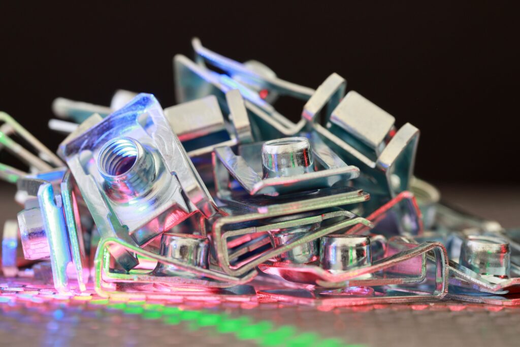 Closeup of metallic hardware pieces with colorful reflections, showcasing industrial elements.