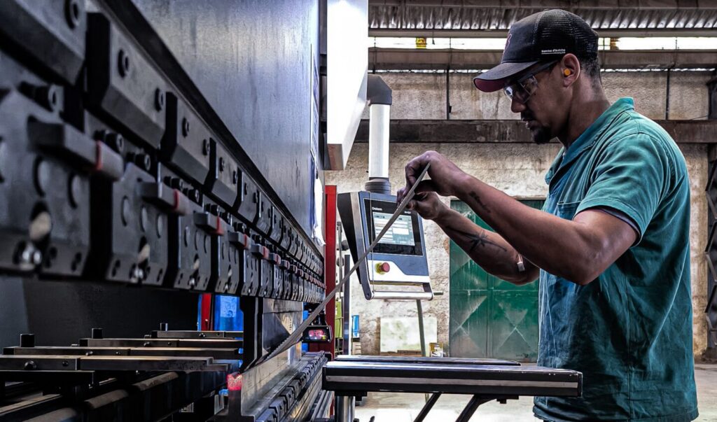 Engineer using machinery in a factory setting, focusing on precision and skill.